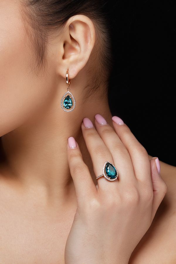 Model shows earrings and ring with beautiful blue precious stone